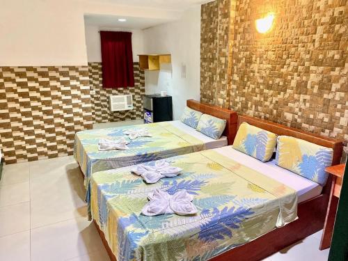 two beds with towels on top of them in a room at Aosmec Square Hotel in Mactan