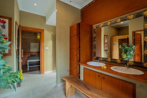 a bathroom with two sinks and a large mirror at Nirmala Guest House Surf Keramas in Keramas
