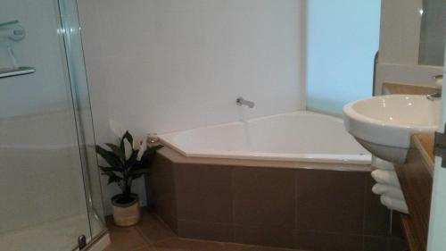 La salle de bains est pourvue d'une baignoire et d'un lavabo. dans l'établissement 340 The Waves, The Esplanade, Cowes, à Cowes