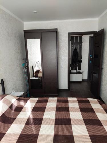 a bedroom with a bed with a checkered floor at Квартира in Karagandy