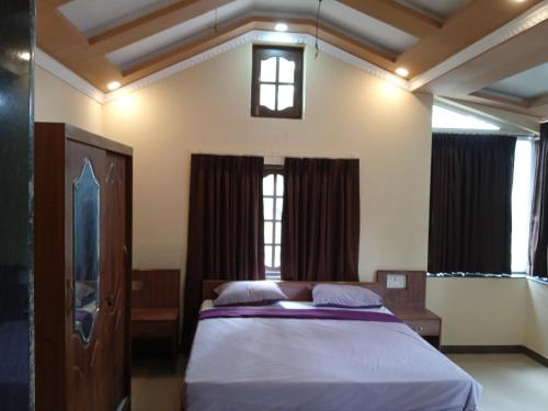 um quarto com uma cama e duas janelas em Casa Coutinho em Porvorim