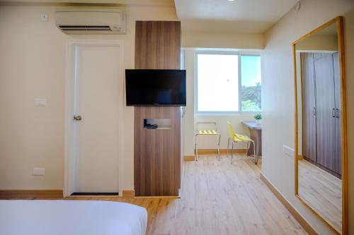a bedroom with a bed and a television in a room at Bloom Hotel - HAL Old Airport Rd in Bengaluru