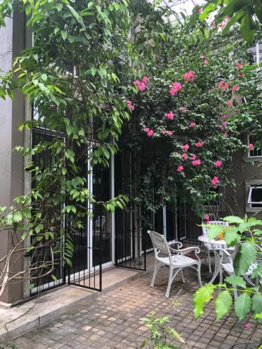 einen Innenhof mit einem schmiedeeisernen Tor mit rosa Rosen in der Unterkunft Write Asia Hollidays in Gampaha