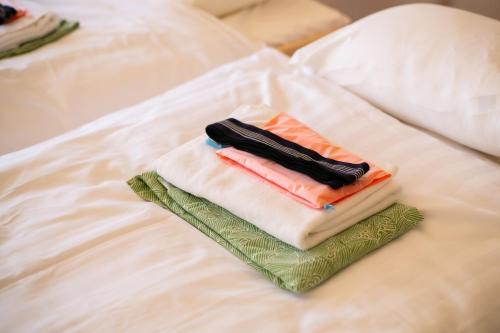 a pile of towels sitting on top of a bed at glampark Healthy Pal Gunma in Shibukawa