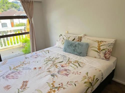1 dormitorio con 1 cama con colcha de flores en Scherff Road Holiday Home en Auckland