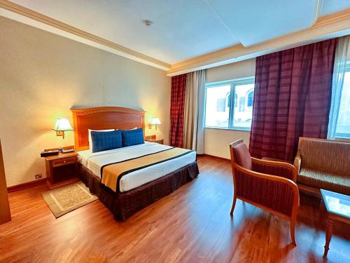 pokój hotelowy z łóżkiem i kanapą w obiekcie Avenue Hotel Dubai w Dubaju