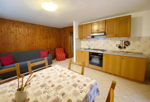 a kitchen with a table and a dining room at La Pineta - Appartamenti In Villetta in Pinzolo