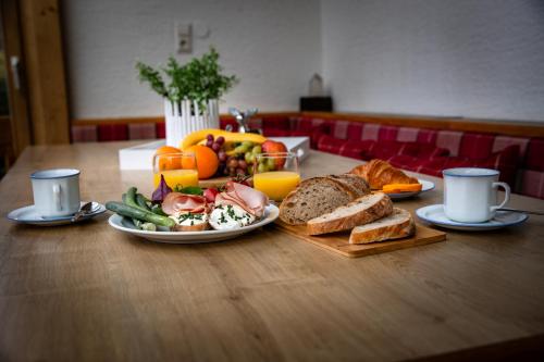 a wooden table with a plate of food and breakfast foods at Villa Frieda mit Zell am See-Kaprun Summer Card in Zell am See