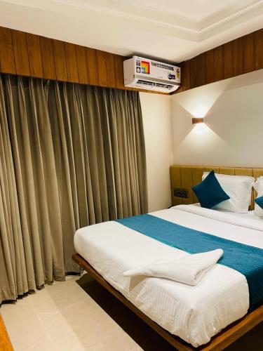 a bedroom with a large bed and a window at Hotel Emora Tree in Mysore