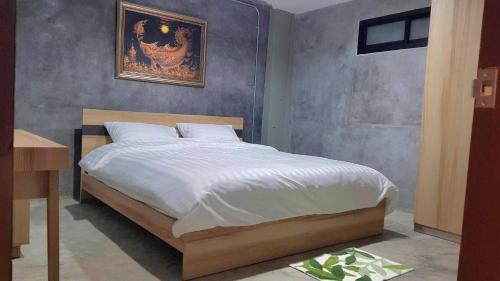 a bedroom with a large bed with white sheets at Captain Joe Cafe & Hostel in Hua Hin