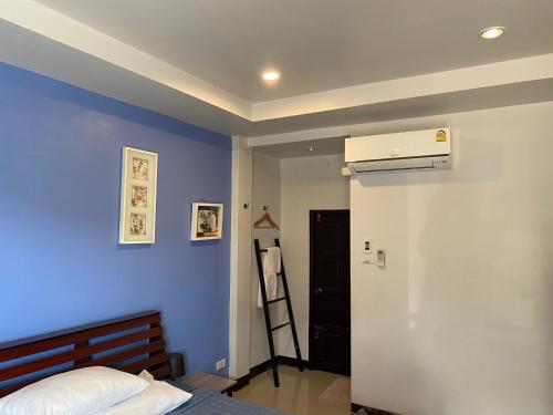 1 dormitorio con cama y pared azul en กัญญ่า เพลส KANYA, en Maha Sarakham