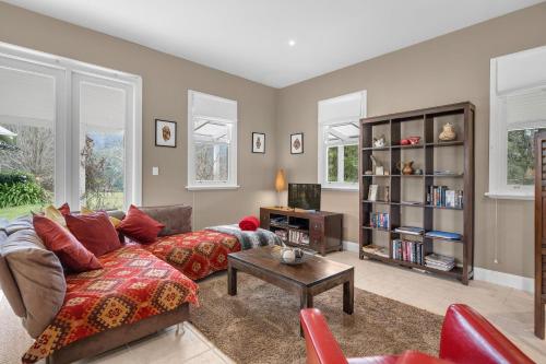 a living room with a couch and a table at Lastover Cottage in Wattamolla