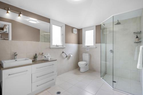 La salle de bains est pourvue d'une douche, d'un lavabo et de toilettes. dans l'établissement Lastover Cottage, à Wattamolla