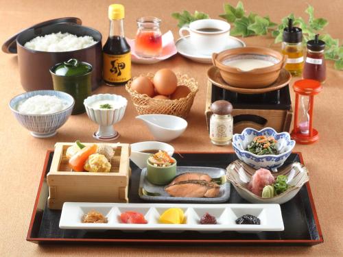 Hotel Binario Saga Arashiyama في كيوتو: طاولة مع صينية من الطعام وغيرها من الأطعمة