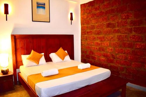 um quarto com uma cama com uma parede de tijolos em City Hostel Colombo Airport em Katunayaka