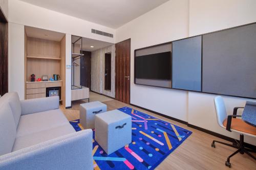 a living room with a couch and a flat screen tv at Aloft Singapore Novena in Singapore