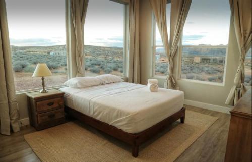 a bedroom with a bed and a large window at Grand Serenity room with Mesa Views in Big Water