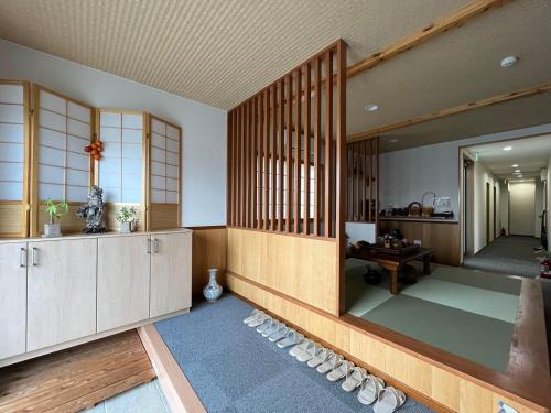Habitación con sandalias en el suelo y espejo en Karin doo Hotel, en Narita