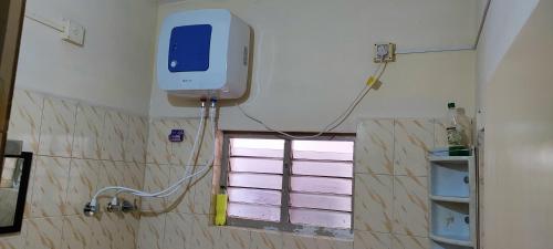 uma casa de banho com uma televisão na parede e uma janela em Chesna Cottage em Madikeri