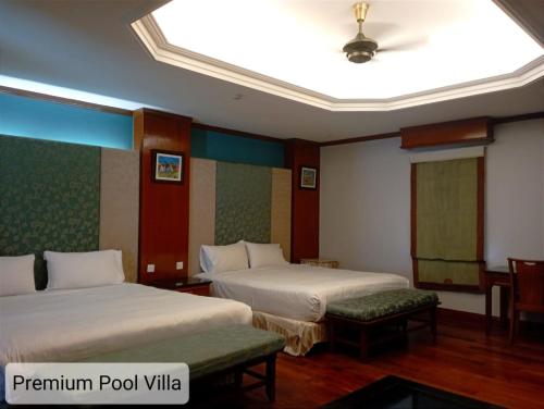 een hotelkamer met 2 bedden en een plafond bij ALPINE GLX PD Port Dickson in Port Dickson