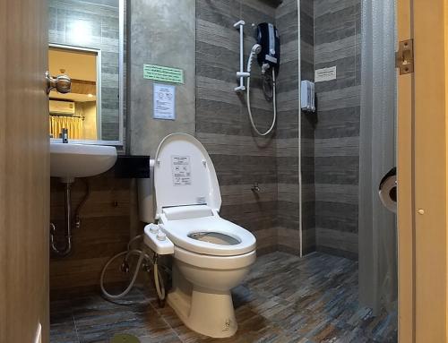 a bathroom with a toilet and a sink at Komol Residence Bangkok in Bangkok