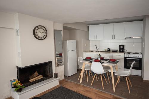 uma cozinha com lareira, mesa e cadeiras em Seacoast apartments 3 ! em Kamena Vourla