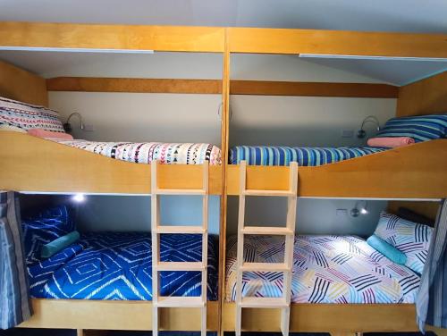 Adventure Wanaka Hostel في واناكا: سريرين بطابقين في غرفة مع سرير