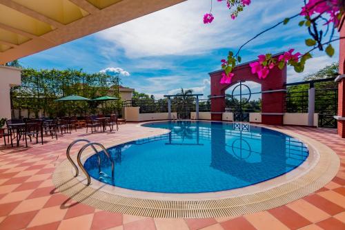 una piscina en la azotea de un edificio con mesas y sillas en Hotel Grand Park Barishal, en Barisāl