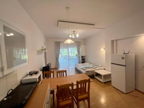 cocina y sala de estar con mesa y nevera en Sosnowy apartament, en Józefów