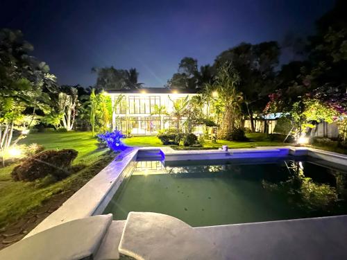 a swimming pool in front of a house at night at G-Hotel Luxury Villa Resort & Hot Spring in Anos