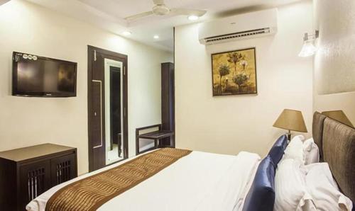 a bedroom with a bed and a flat screen tv at FabHotel Prime Hema's Supreme in Visakhapatnam