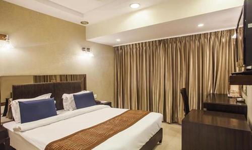 a hotel room with a large bed and a desk at FabHotel Prime Hema's Supreme in Visakhapatnam