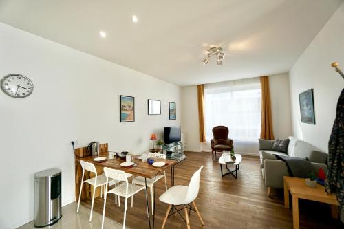 un salon avec une table, des chaises et un canapé dans l'établissement Le Citadin *2min gare*centre ville* terrasse*, à Lorient