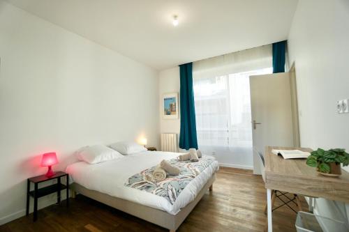 une chambre avec un lit, un bureau et une fenêtre dans l'établissement Le Citadin *2min gare*centre ville* terrasse*, à Lorient