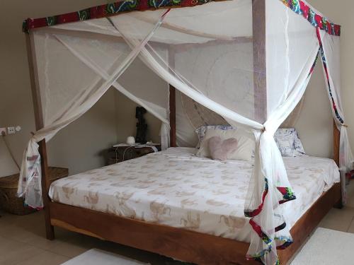 a bed with a canopy in a bedroom at POMBO KUNDA Room in Sanyang