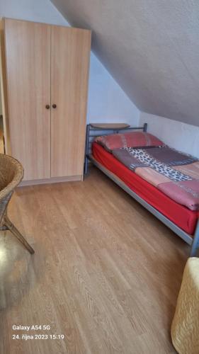 ŘežにあるPension Egidaのベッドルーム1室(ベッド1台付)、木製キャビネットが備わります。