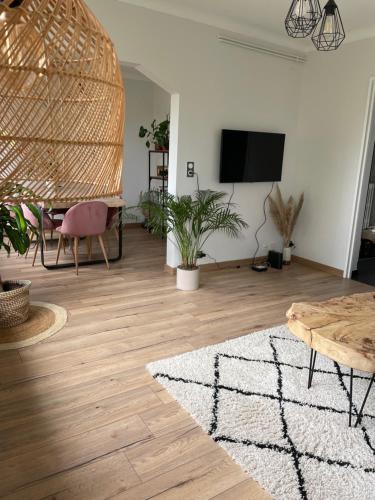 sala de estar con mesa y TV en la pared en Appartement F3 Cocooning, en Montigny-lès-Metz