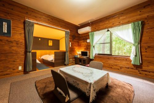 a bedroom with a bed and a window in a room at Yufuin Tsukahara Kogen Sanso Donguri in Yufuin