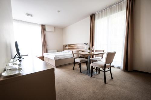 a hotel room with a bed and a table and chairs at Hotel Monínec in Moninec