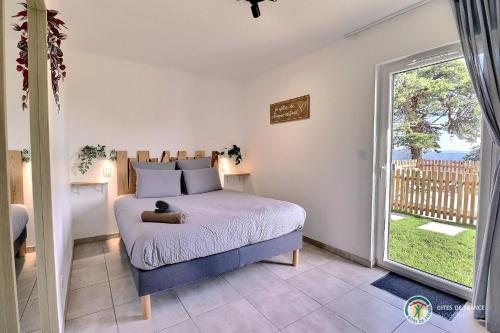 une chambre avec un lit et une grande fenêtre dans l'établissement La BOOA - Écolodge en Ardèche - Piscine privée - Ecolodgîte, à Ozon