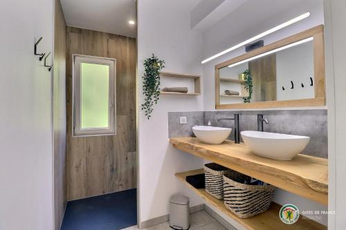 une salle de bain avec deux lavabos et un miroir dans l'établissement La BOOA - Écolodge en Ardèche - Piscine privée - Ecolodgîte, à Ozon