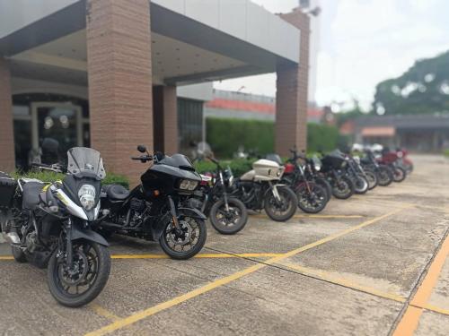 a row of motorcycles parked in a parking lot at Mayflower Grande Hotel Phitsanulok in Phitsanulok