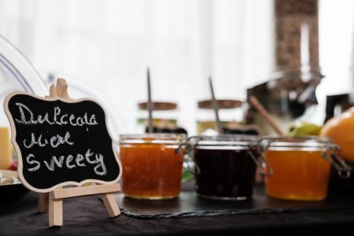 a table topped with glasses of honey and a chalkboard at Hotel Clipa in Drobeta-Turnu Severin