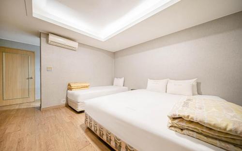 a bedroom with two white beds and a skylight at Vov Hotel in Busan