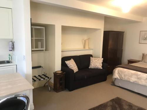 a bedroom with a bed and a couch and a bed at Belton Apartments - The Studio in Hobart