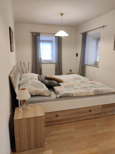 a bedroom with a large bed with a night stand at Ferienhaus Am Bach in Kirchberg an der Raab