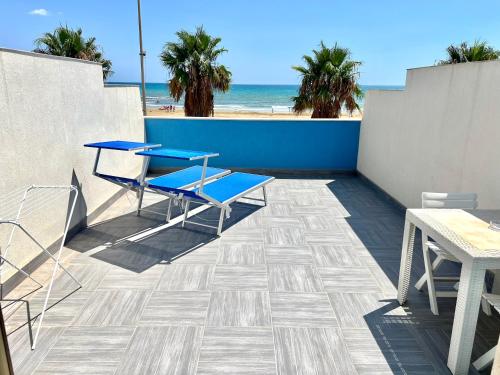 a patio with a table and chairs and the beach at Terrazze Sul Mare in Pozzallo
