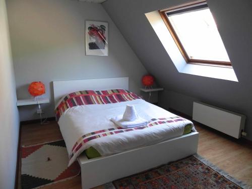 a small bedroom with a bed with a window at Gite Des Trois in Orschwiller