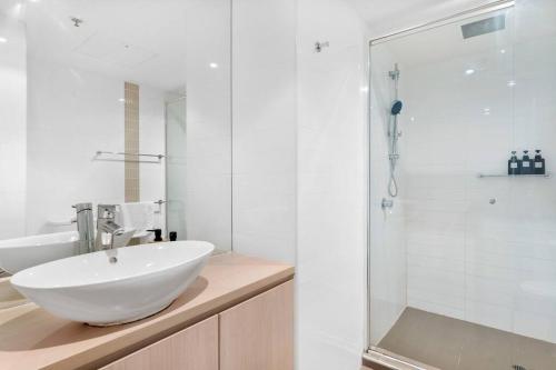a white bathroom with a sink and a shower at Little escape at Balfours 1BR Wifi Spa Swim in Adelaide