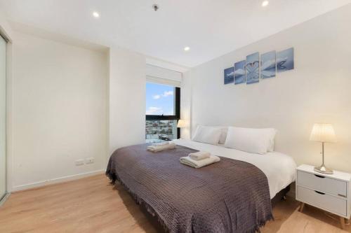 een slaapkamer met een bed met twee handdoeken erop bij Little escape at Balfours 1BR Wifi Spa Swim in Adelaide
